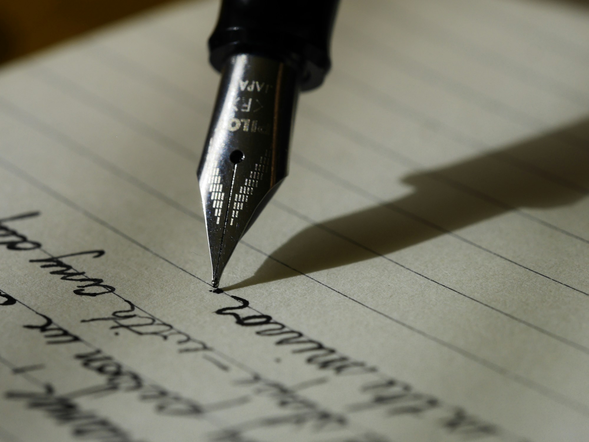 Close-up of a pen writing on paper
